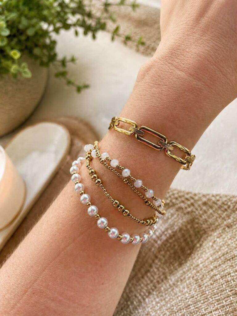 Gold Eloise pearl stretch bracelet set layered with a chunky gold chain bracelet for a modern casual look.