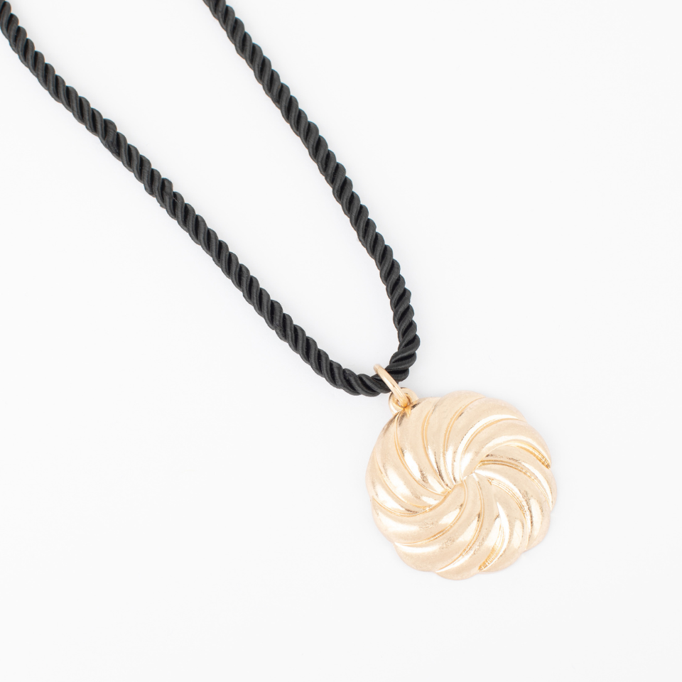 Ebony Necklace with a sculptural gold swirl pendant on a twisted black cord.