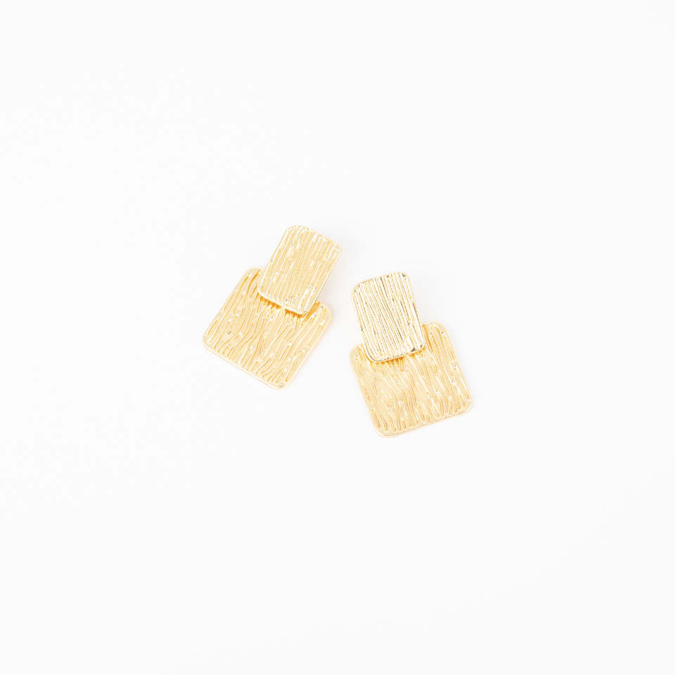 Margot gold statement earrings with layered geometric shapes and textured surfaces.