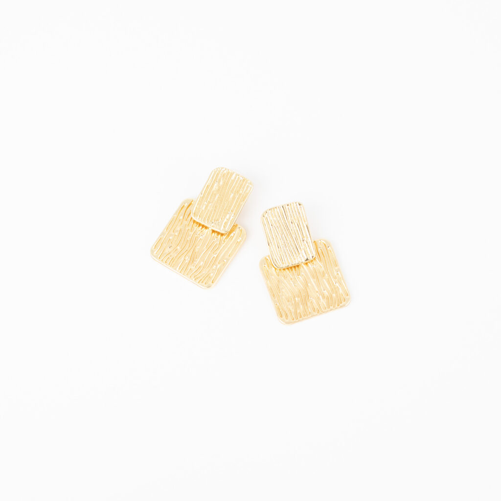 Gold Margot post earrings featuring layered rectangular shapes with textured linear detailing on a white background.