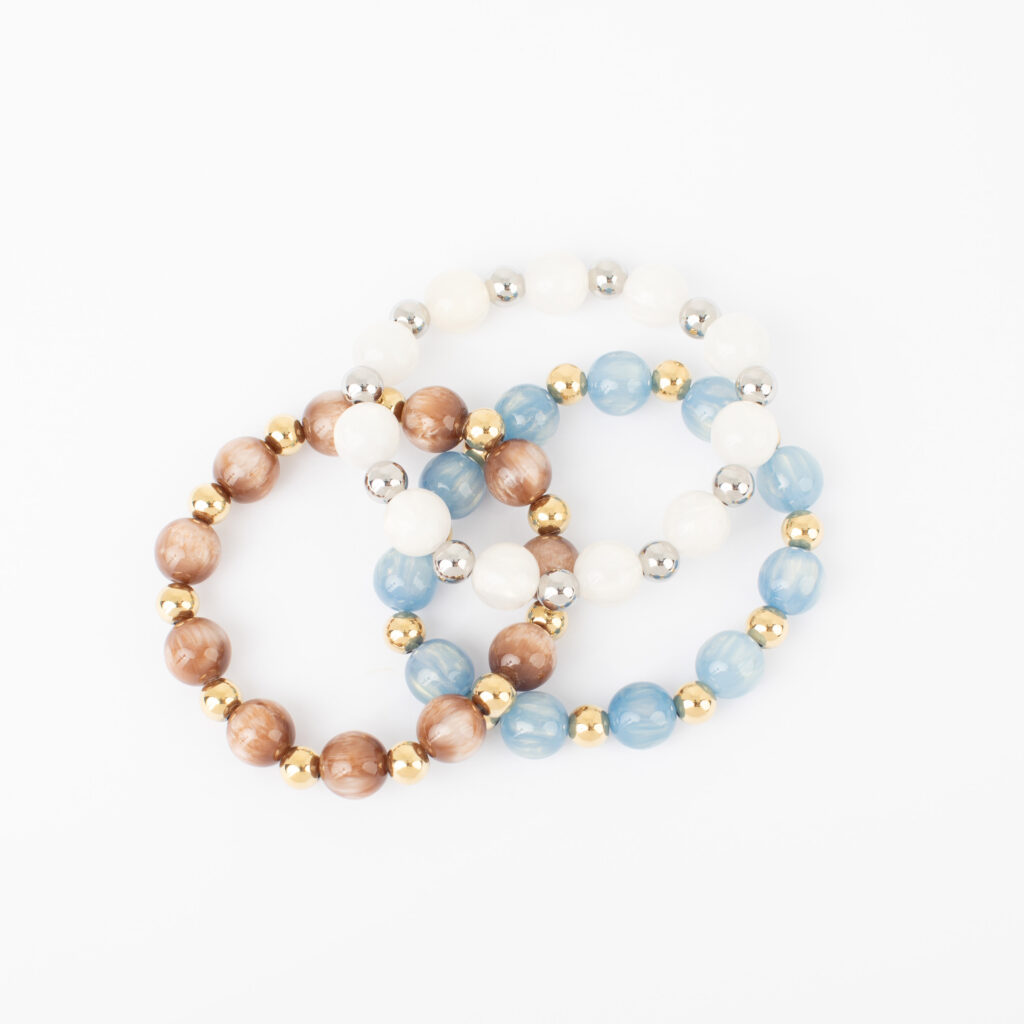 Fallon Stretch Bracelet Set featuring white, light blue, and warm brown beads with silver and gold accents.