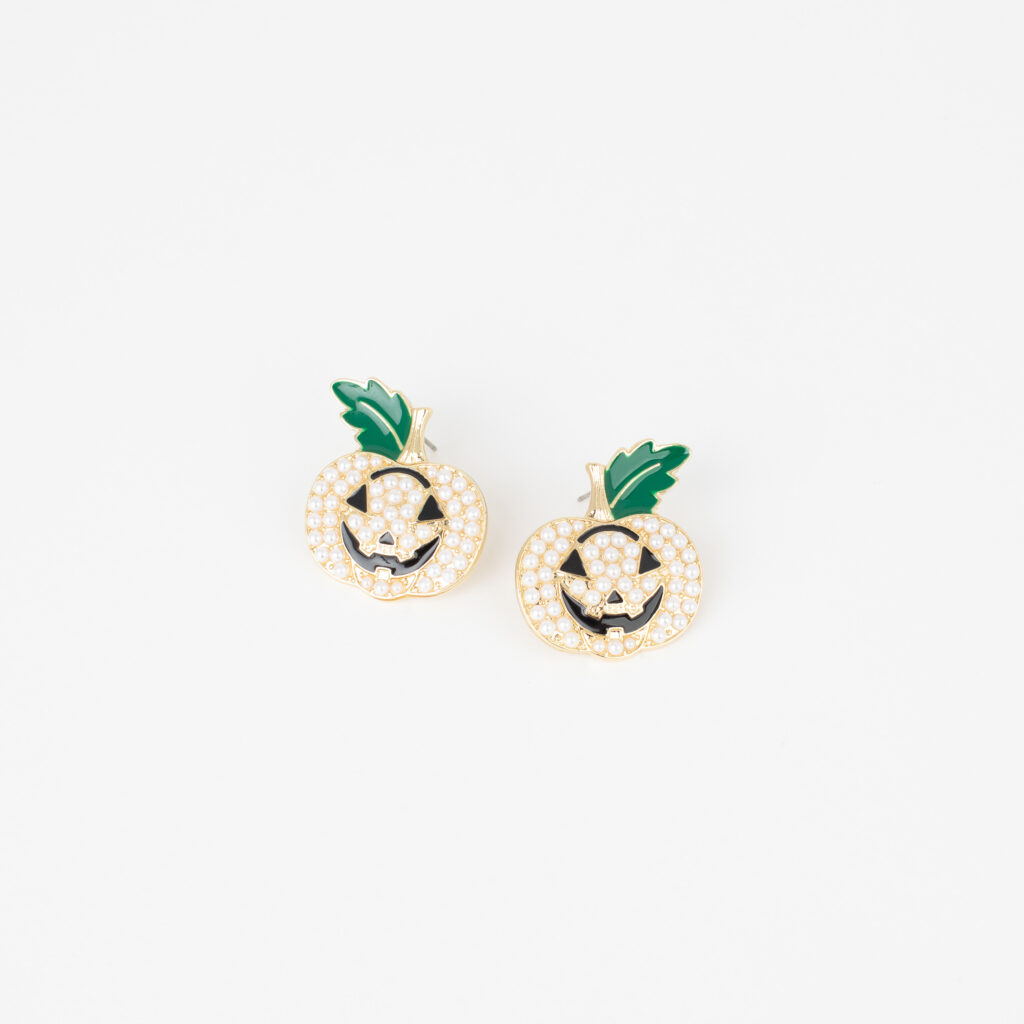 Gold jack-o’-lantern earrings decorated with pearls, black facial details, and green leaves.