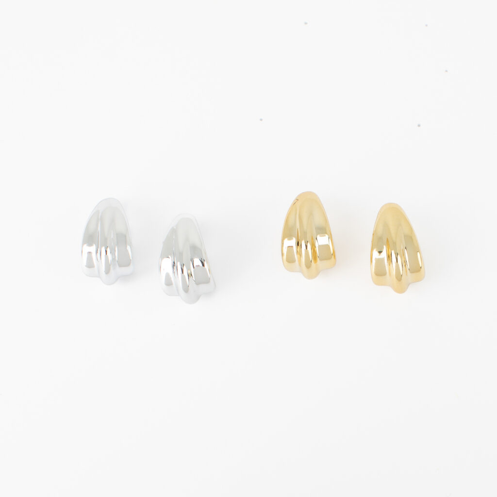 James earrings shown in polished silver and gold finishes with a sculptural three-ridge design.