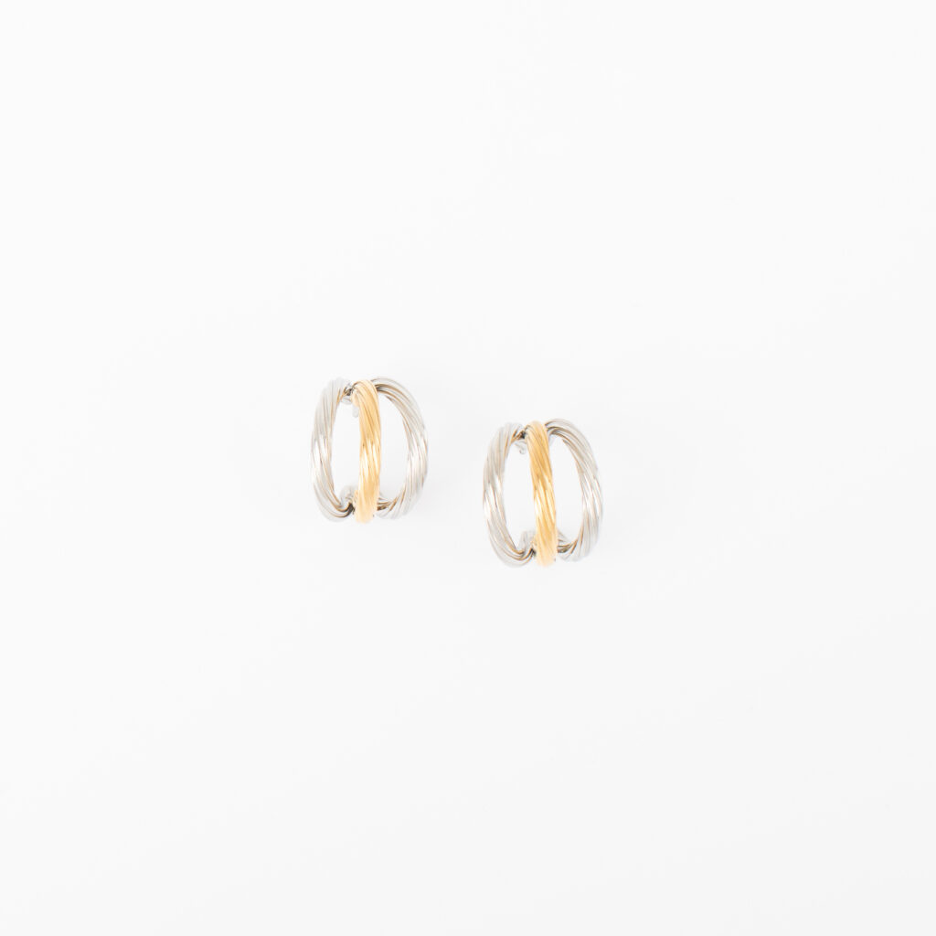 Lola hoop earrings featuring intertwined polished gold and silver bands on a white background.