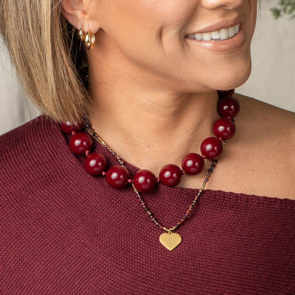 Angela personalized heart necklace layered with a separate burgundy bead necklace