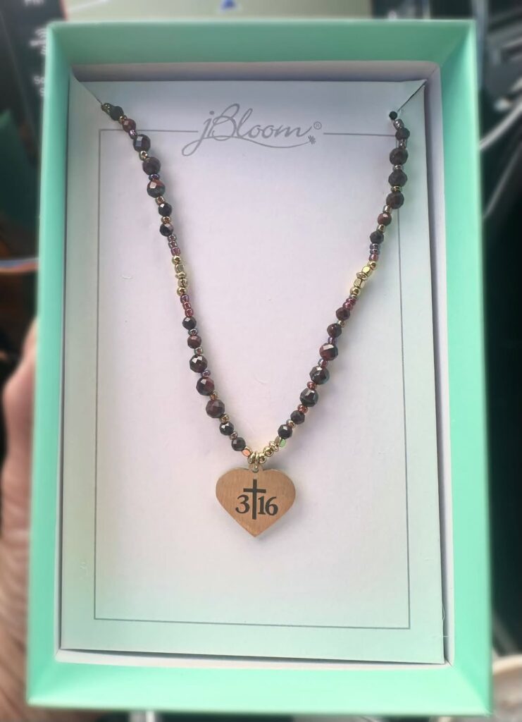 Angela beaded necklace in a jewelry box with a gold heart pendant personalized with a cross and 3:16