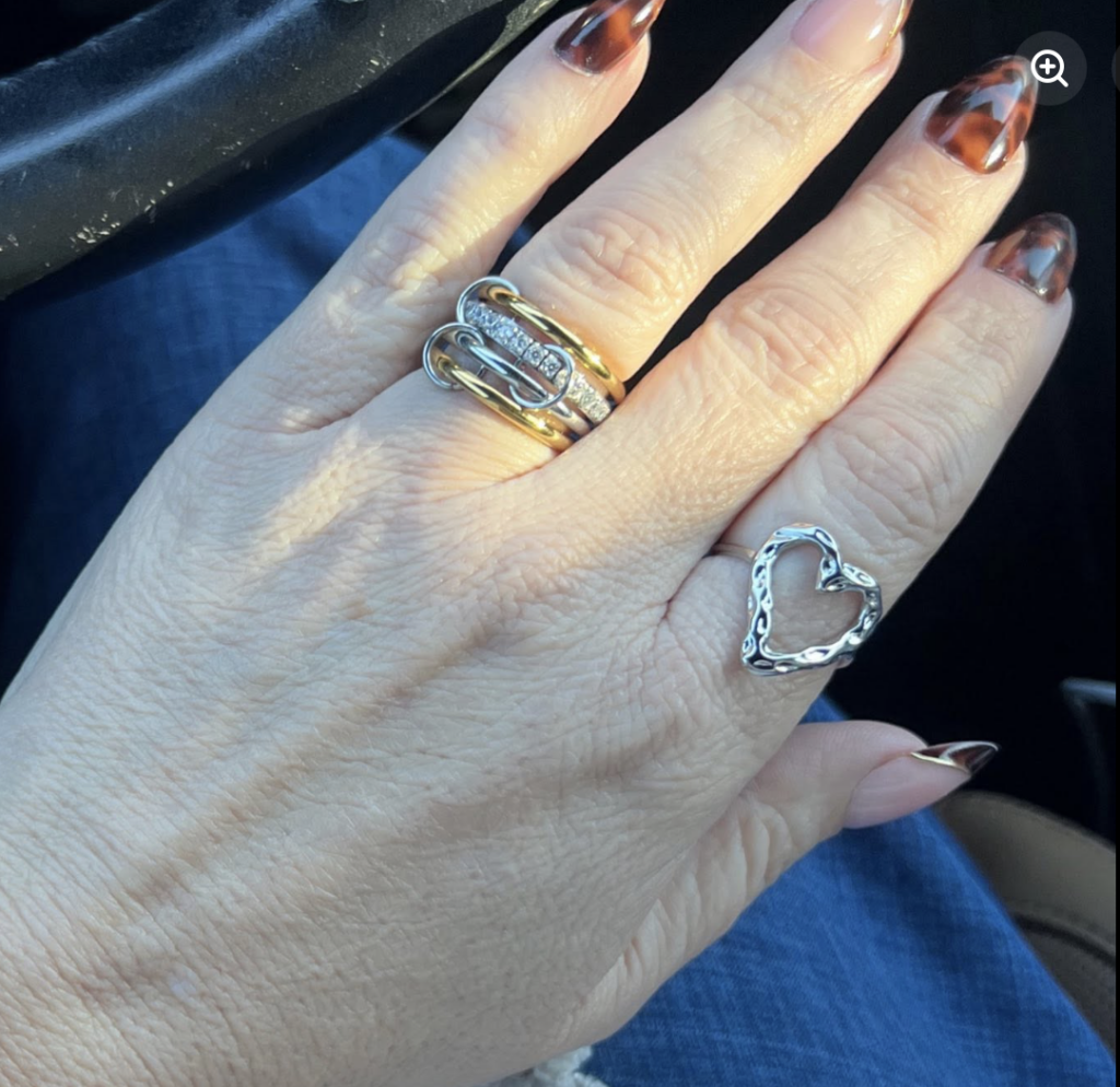 Bebe mixed-metal statement ring shown worn on a hand