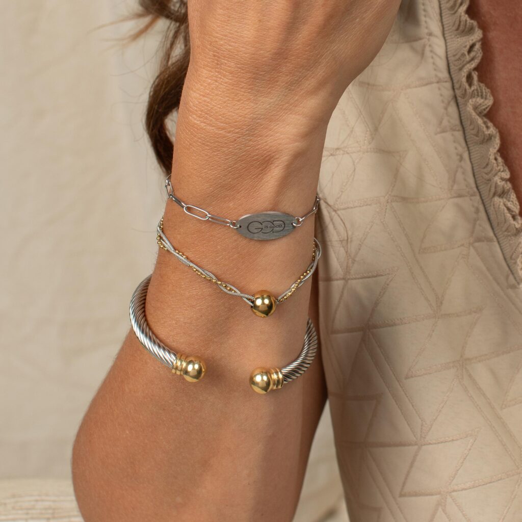 Frankie two-tone cuff bracelet styled on the wrist with other bracelets