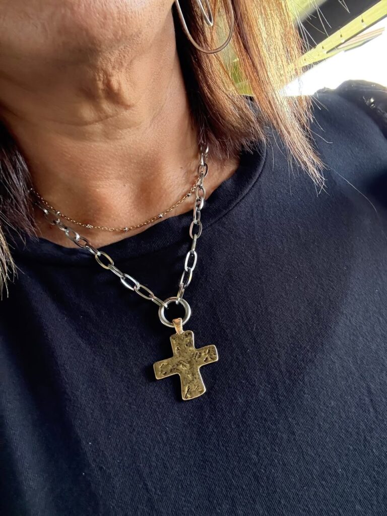 Close-up of the silver Lora Necklace and gold Hammered Cross Charm