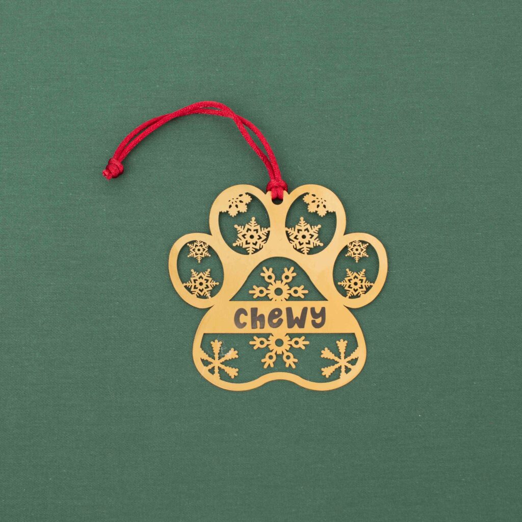 Gold paw print ornament personalized with Chewy and snowflake details